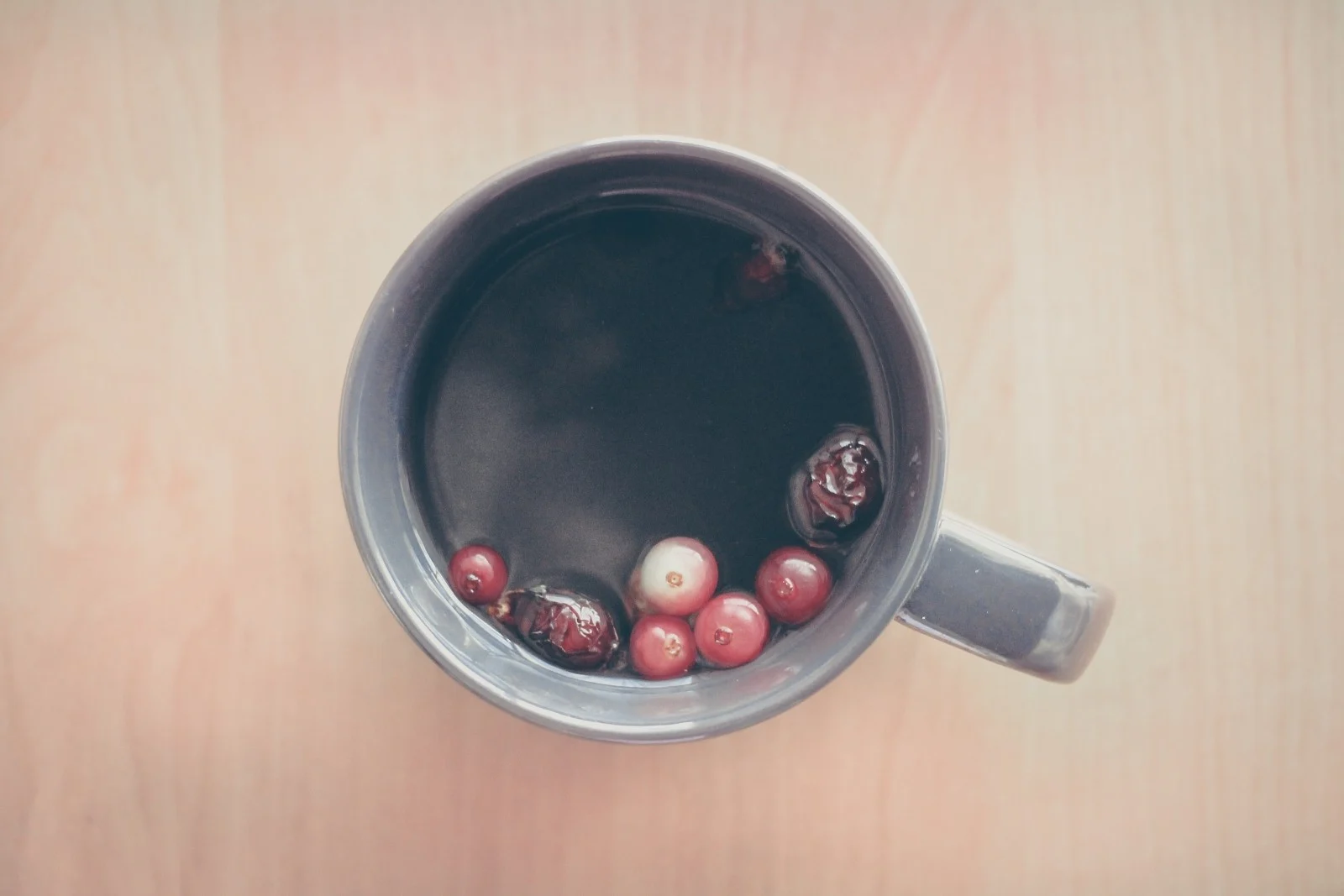 Cup of berry tea with berries floating to the top